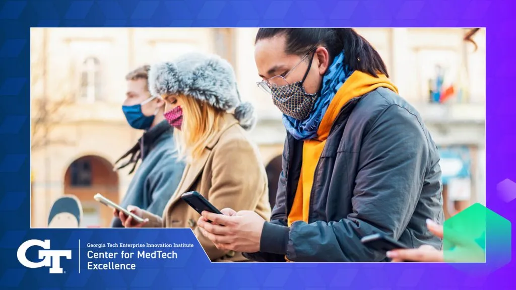 image of people outside with masks on and looking at their phones